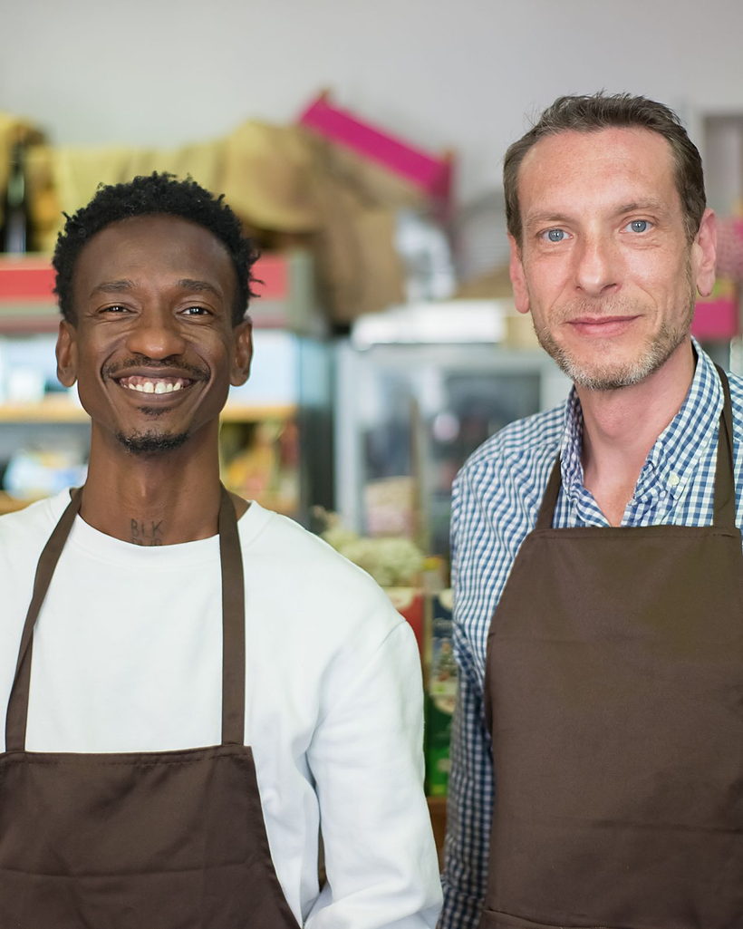 Two shop owners standing together behind their counter